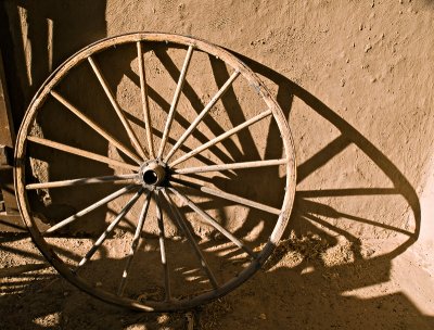 In the small courtyard -- wagon wheel in sunlight