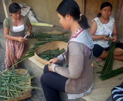 Women plaiting palm leaf baskets for offerings