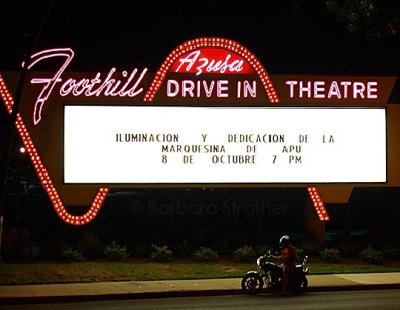 A biker stops to read the Foothill Drive-In sign in Azusa, CA, on the night of its historic re-lighting.