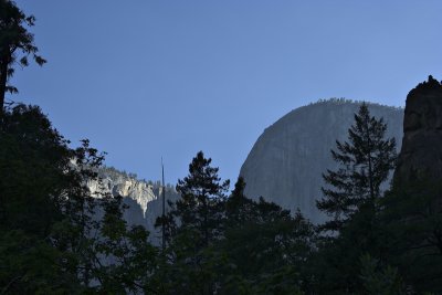 Rock faces loom over the trees above us