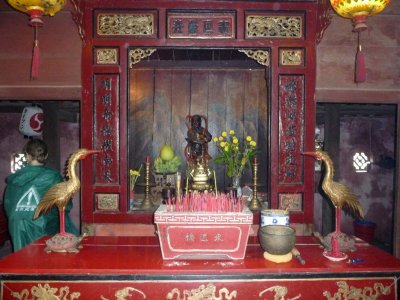 A small Buddhist shrine with incense offerings on the Japanese Covered Bridge.