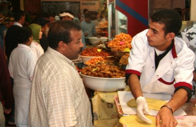 This man was negotiating a transaction at the food market.