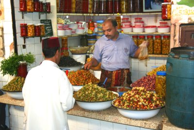 Olive vendor in a food market (souk) in Fs.