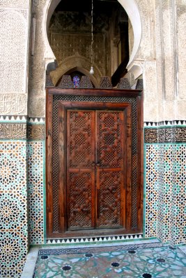 Beautifully carved wooden door and mosaics in the medrassa.
