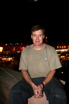 Me sitting on a wall of the Moroccan pizza restaurant overlooking Place Djemaa El-Fna.