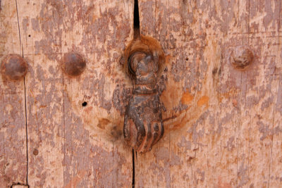 A door at ait Ben Haddou where this rusty hand was used as a door pull.