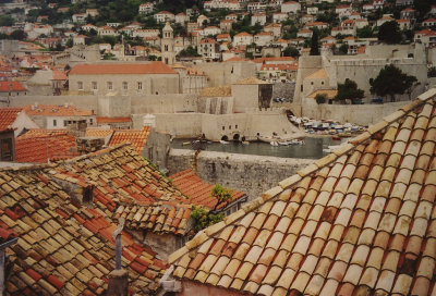 Tiled Dubrovnik rooftops with the Old Port in the background.