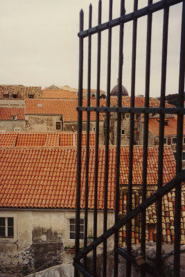 More red rooftops beyond the iron gate.