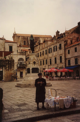 A woman vendor selling linens in front of Statue in Gundulic Square.