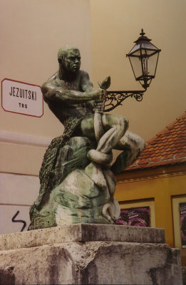 Serpentine statue and lamppost at Jezuitski Square in Zagreb.