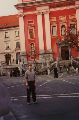 Me standing in front of the Franciscan Church in Ljubljana. It stands out due to its red color.