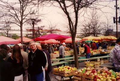 A fruit and vegetable market in Ljubljana with people shopping.