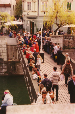People crossing the Ljubljanica River on the Shoemakers Bridge.