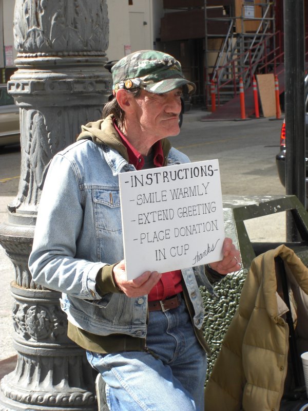 Read his sign;  enlarge it