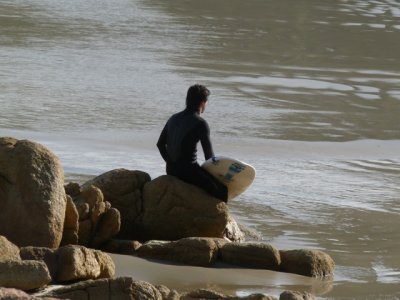 A surfer waits for his friend at Praia do Rosa Beach in Santa Catarina, Brazil