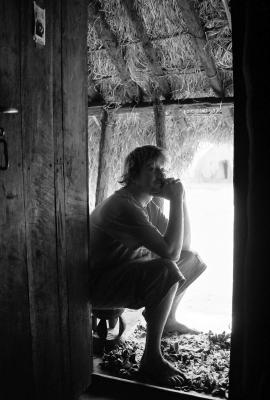 Zambia - Aaron on stool  at door to his hut
