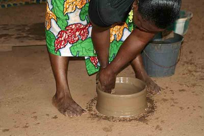 Pottery village S. No potters wheel to facilitate the work. The woman is turning round and round her pot.