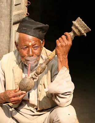 Smoking a Nepali pipe.