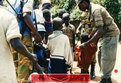 An RPA soldier (wearing redundant East German Army uniform) shows humanity in offering water to displaced children.