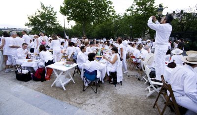 This is apparently called Le Dner en Blanc, and happens once a year at random locations around Paris.
