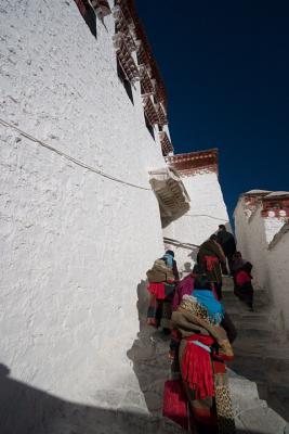 A few pilgrims walking into one of Potala's many chapels.
