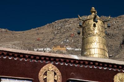 Top of one of the chapels in Sera with a chapel high in the mountains behind for the more enlightened monks.