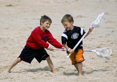 Brothers Play Lacrosse on the Beach