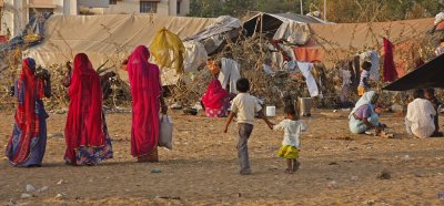 Three Women Approaching Tent Camp