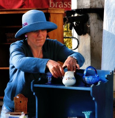 The lady in blue sells pottery....