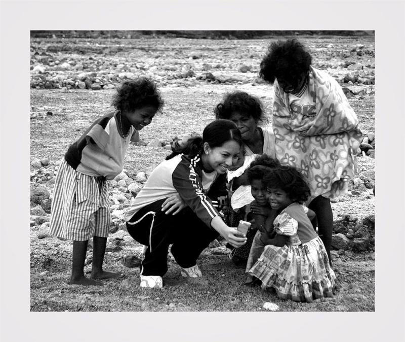 Pamapanga, Philippines. Cheap Thrills. One member of our group shows a digital picture to some of the locals