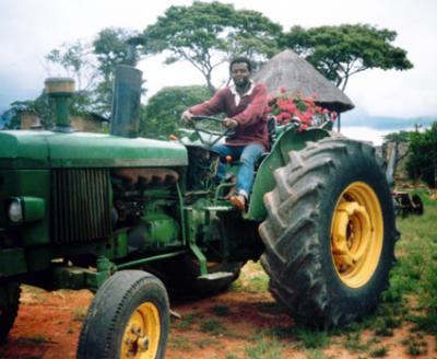 Chai driving the tractor barefoot.jpg