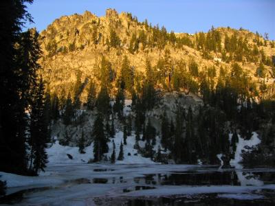 Doe Lakes sunrise glows on ice, snow, and rock in July