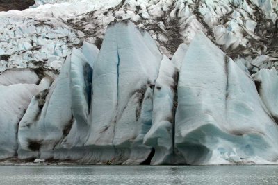 A kayaker is dwarfed by the face of the Mendenhall Glacier