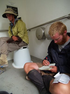 P7173258 Hikers taking shelter from rain in a parking lot toilet facility.JPG