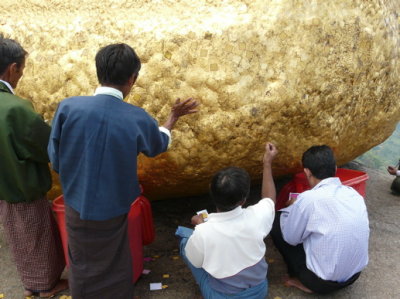 worshippers applying gold on to the rock