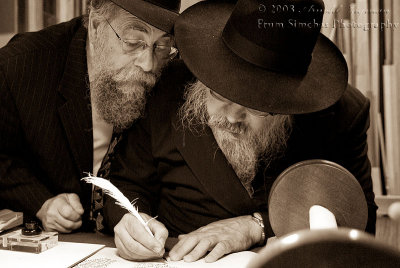 Rabbi Marcus completing the last letter with Rabbi Newman looking on