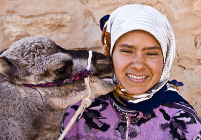 A young woman and a Dromedary baby