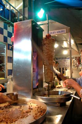 slicing meat from a revolving grill for a doner kebab
