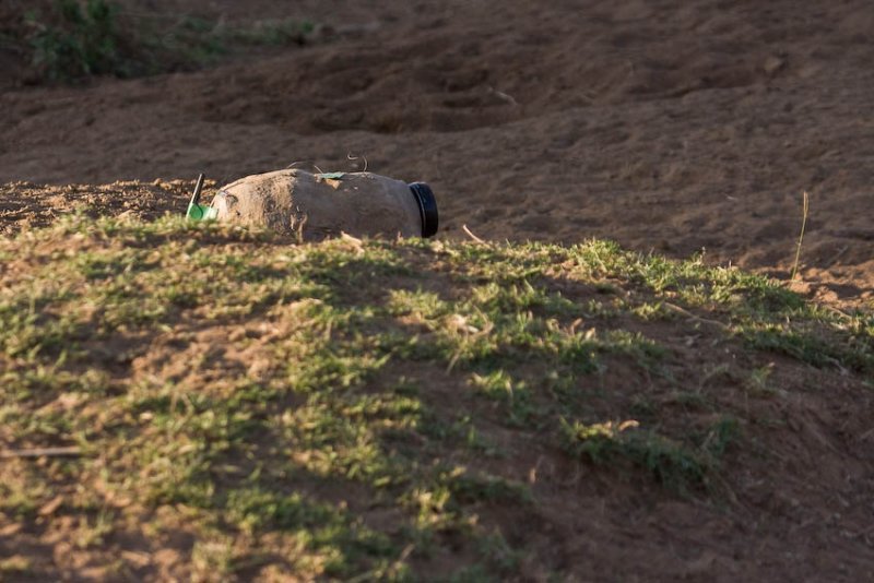 Remote controlled camera disguised with mud at a crossing site.