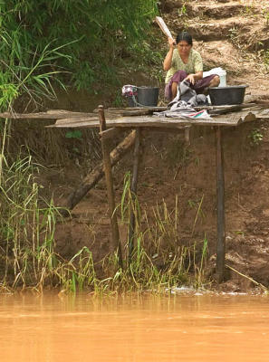 Woman washing clothes by the Mekong river, Golden Triangle