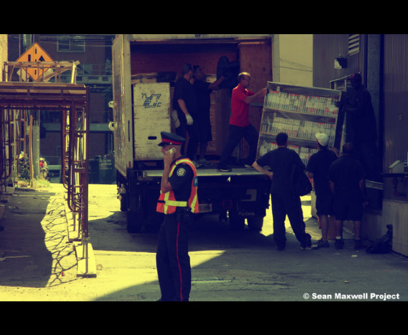 Toronto Canada - Police Officer on Cell Phone and Movers