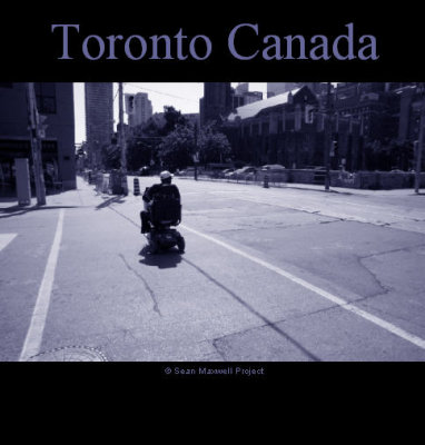 Toronto Canada - Man in Wheelchair Crossing Street at crosswalk
