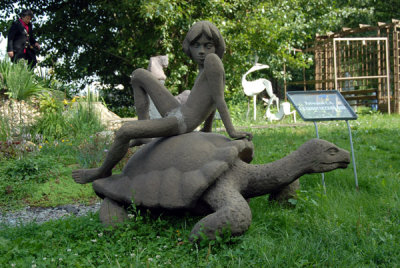 Statue of Mowgli from Disneys The Jungle Book sitting on a tortise, Sculpture Garden of the House of Artists