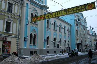 Banner adversitsing a Moscow restaurant in front of a pretty blue building (Historical Archives Institute) Nimerkolskaya ulitsa