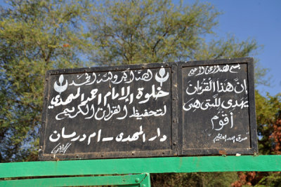 Sign over the side door to the garden behind the Tomb of the Mahdi