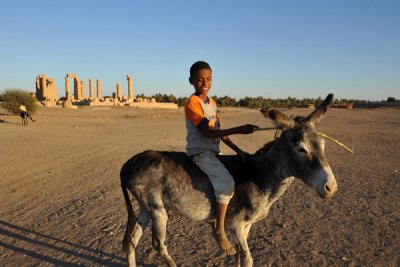 Nubian boy on a donkey in front of the Temple of Soleb