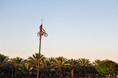 Figure riding on moped on a post near the north end of the Dead Sea