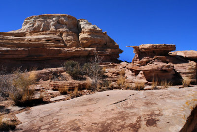 Over the slab, between the rocks, and up a shelf going around the hump