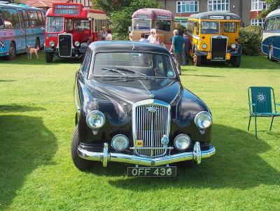 Wolseley with various buses in the background.