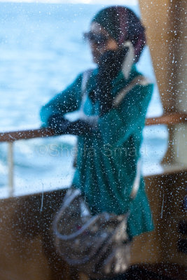Woman through salt sprayed ferry window